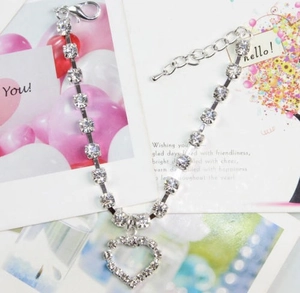 Macro detail of rhinestone pet necklace with heart pendant and adjustable silver chain