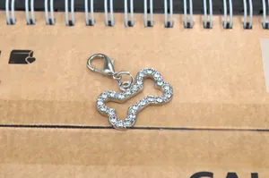 Close-up of a silver bone-shaped pet charm with white rhinestones and a lobster clasp