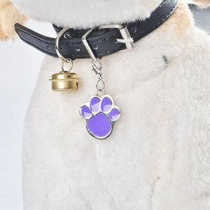 Purple paw-shaped metal pet tag with bell and lobster clasp on black leather collar