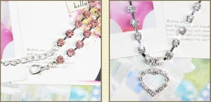 Detailed view of silver heart pendant with pink rhinestones and lobster clasp on pet necklace