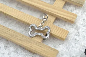 Macro shot of silver bone-shaped pet charm with rhinestones and lobster clasp