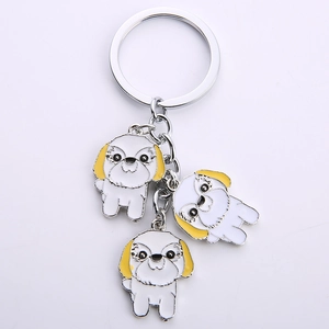 Detailed view of silver keychain featuring three cute enamel white and yellow dog charms