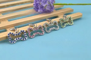 Detailed view of four rhinestone bone-shaped pet collar charms in various vibrant colors
