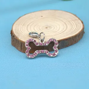 Close-up of a silver bone-shaped pet charm with pink rhinestones and lobster clasp
