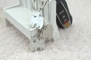 Detailed front and back view of Samoyed dog enamel keychain with gold metal edges