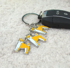 Macro view of Shiba Inu enamel pendant keychain with polished silver metal ring detail