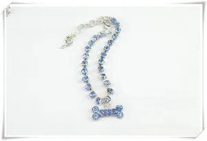 Detailed close-up of a bone-shaped pet charm featuring blue rhinestones and silver chain