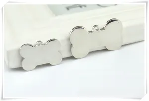 Close-up of bone-shaped zinc alloy pet ID tags with a polished mirror finish surface
