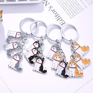 Detailed close-up of four metal dog keychains with enamel husky and shiba inu charms