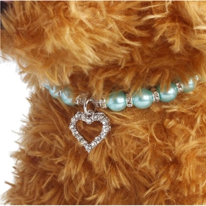 Close-up of pet pearl necklace with light blue beads and heart-shaped crystal pendant