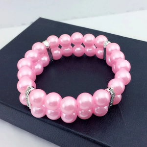 Gros plan d'un collier pour animaux en perles roses doubles avec anneaux en strass