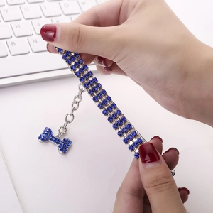 Détail du collier pour animaux en strass bleus avec un pendentif en forme d'os brillant
