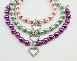 Detail of colorful pearl pet collars with rhinestone heart pendants and lobster clasps