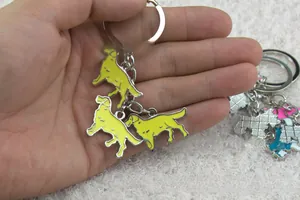 Detailed close-up of metal golden retriever pendants with yellow enamel and silver finish