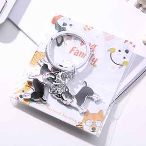 Detail of Boston Terrier metal keychain with dog family packaging card on a desk
