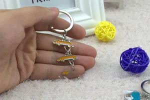 Detail view of a silver Dachshund keychain with orange enamel held in hand