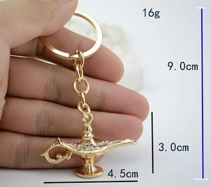 Golden Aladdin lamp keychain size and weight dimensions shown in hand measurements
