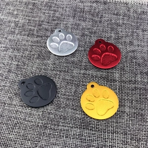 Aluminum pet ID tags in four colors with embossed paw prints and round hanging holes