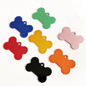 Flat lay of seven bone-shaped aluminum pet ID tags in assorted vibrant colors on white