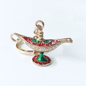 Detailed close-up of golden Aladdin lamp keychain with red enamel and sparkling rhinestones