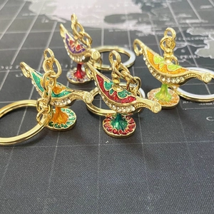 Detailed macro view of colorful metal Aladdin lamp keychains with shiny rhinestones