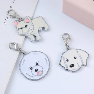 Close-up of alloy pet pendants showing French Bulldog and Golden Retriever designs