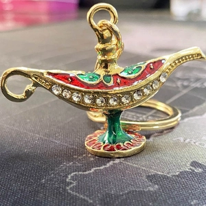 Detail of Aladdin magic lamp keychain with gold finish, colorful enamel and rhinestones