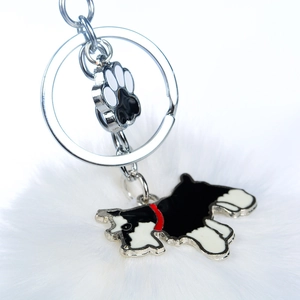 Détail du porte-clés en métal avec breloque chien Schnauzer et pompon en fausse fourrure