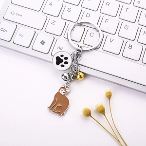 Enamel cat keychain with brown kitty pendant and paw charm on computer keyboard