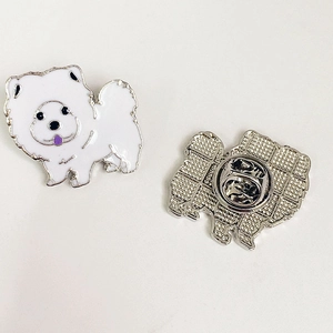 Détail montrant le devant de la broche chien en émail blanc et l'envers avec attache papillon