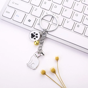 Detailed view of cat keychain with white enamel kitten pendant, paw charm and bells