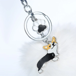Détail de porte-clés Corgi en émail avec pompon blanc et breloque empreinte de patte