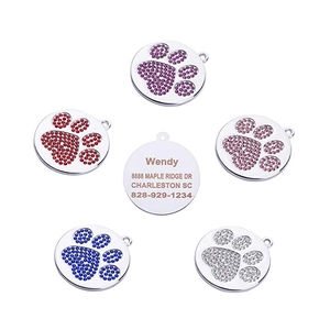 Detail of round rhinestone paw print pet ID tags with laser engraved name and contact info