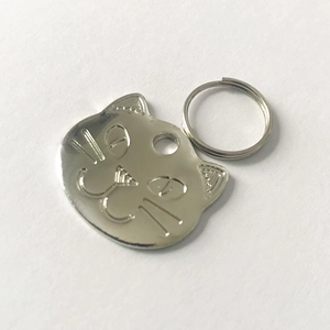 Detailed view of cat-shaped stainless steel pet ID tag with embossed facial features