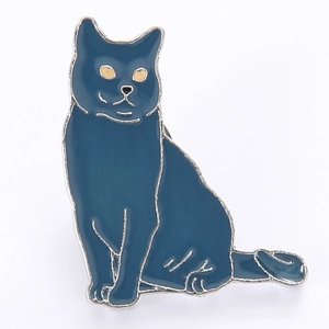 Détail d'une broche chat en émail bleu foncé avec bords argentés et yeux jaunes