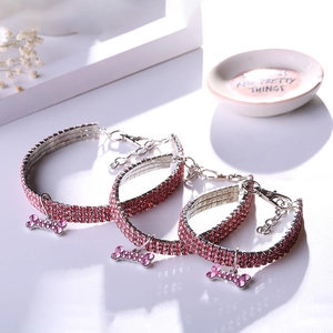 Detailansicht eines rosa Strass-Halsbandes mit glitzerndem Knochenanhänger für Haustiere
