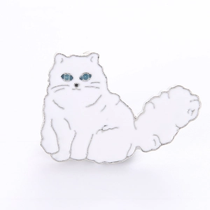 Gros plan détaillé d'une broche chat en émail blanc avec yeux bleus et contour argenté