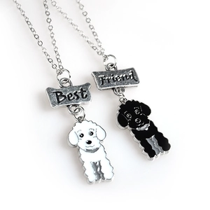 Détail des pendentifs Best Friend en forme d'os avec breloques de chiots noir et blanc