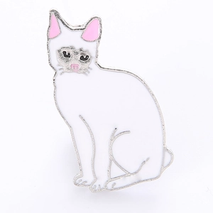 Gros plan détaillé d'une broche chat en émail blanc avec bordures argentées et détails