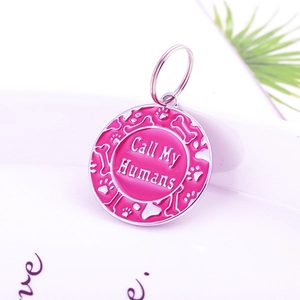 Détail de la médaille ronde rose pour chien avec texte 'Call My Humans' et motifs d'os