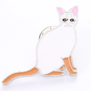 Détail de la broche chat en émail blanc et orange avec bordures en alliage poli