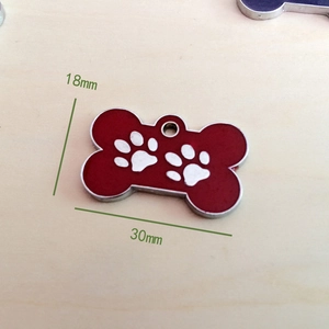 Makroansicht der 30mm roten Hundemarke in Knochenform mit Pfotenabdrücken und Emaille-Finish