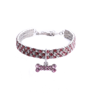 Détail d'un collier à trois rangées de strass pour animaux avec pendentif os rose mignon