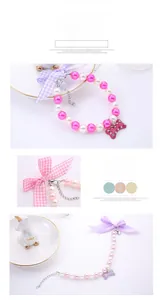 Close-up of pink and white pearl pet collar with rhinestone bone pendant and bow