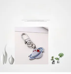 Detail of metal planet keychain with galaxy theme and star pattern on D-spring clasp