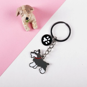 Detail of Schnauzer dog keychain with black paw pendant on pink and white backdrop