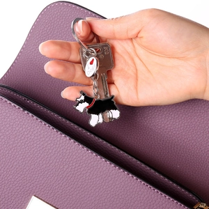Detail of Schnauzer enamel keychain with I Love Dogs tag on a purple leather bag