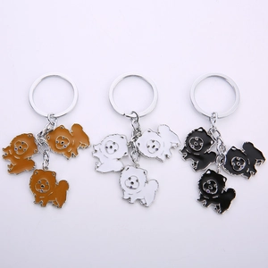 Detailed macro of enamel dog keychains in brown, white, and black with metal rings