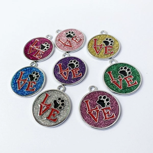 Close-up of glitter metal pet tags with LOVE letters and paw print details