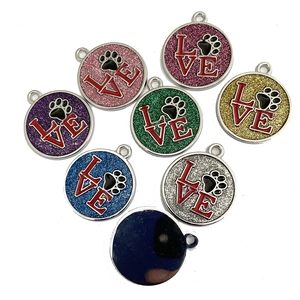 Detailed view of colorful glitter pet ID tags with LOVE text and paw print design